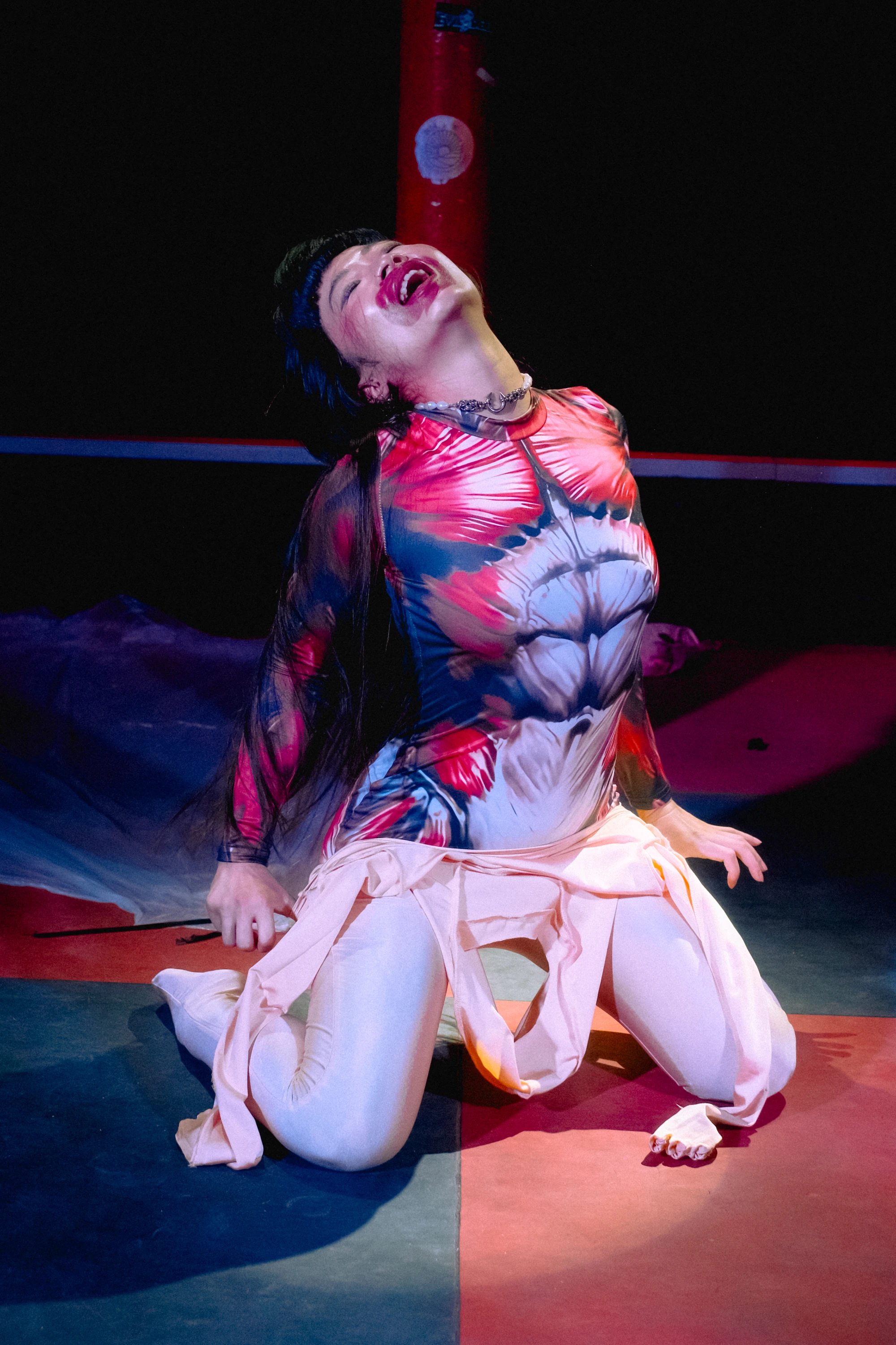 a woman peels off her flesh colured bodysuit to reveal a anatomical muscle suit underneath.