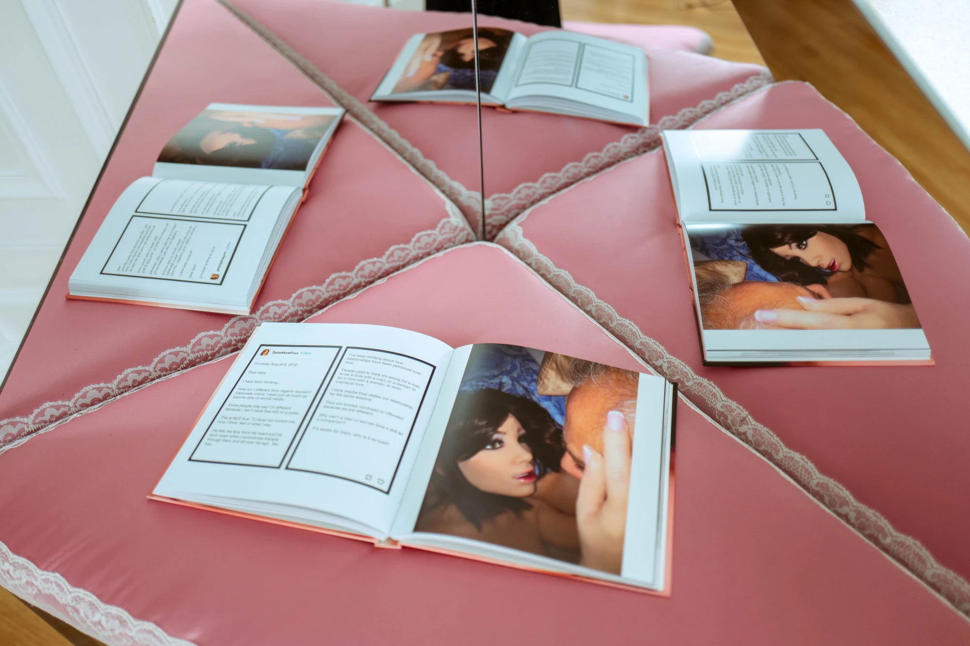 a book open across pink satin fabric.