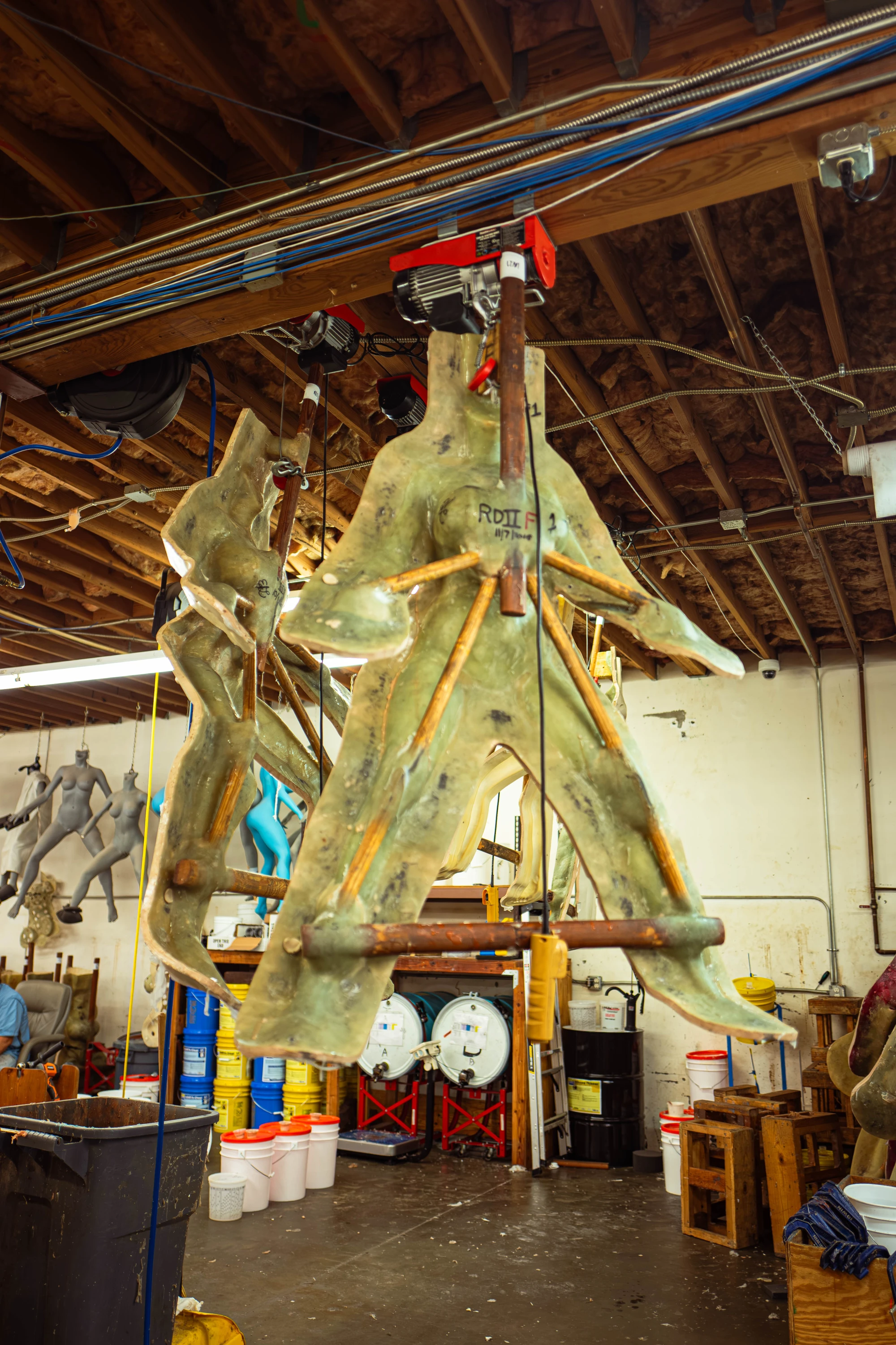 cast moulds hang from the ceiling of a factory.