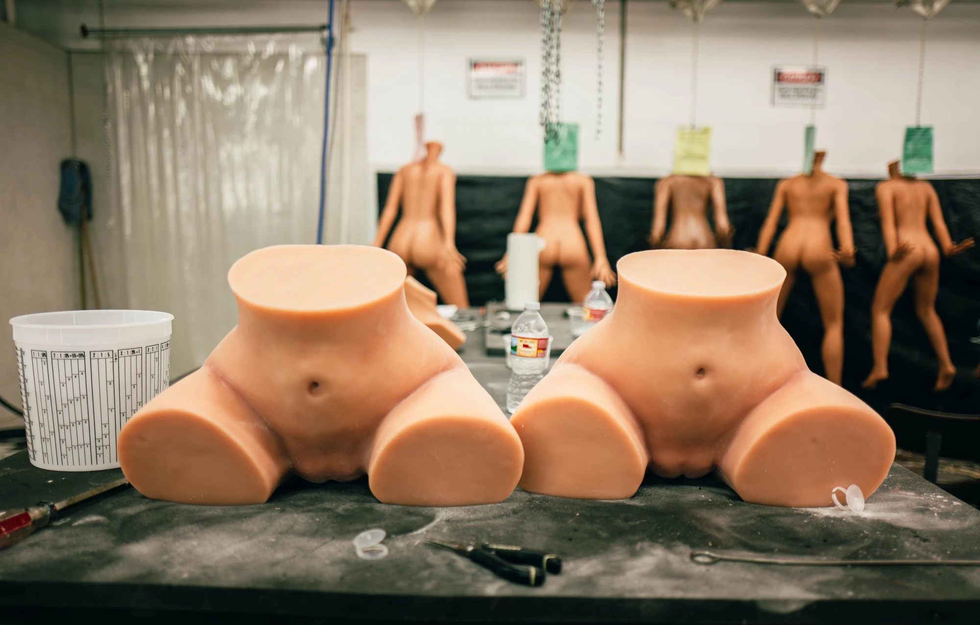 two silicone torsoes sit on a table.