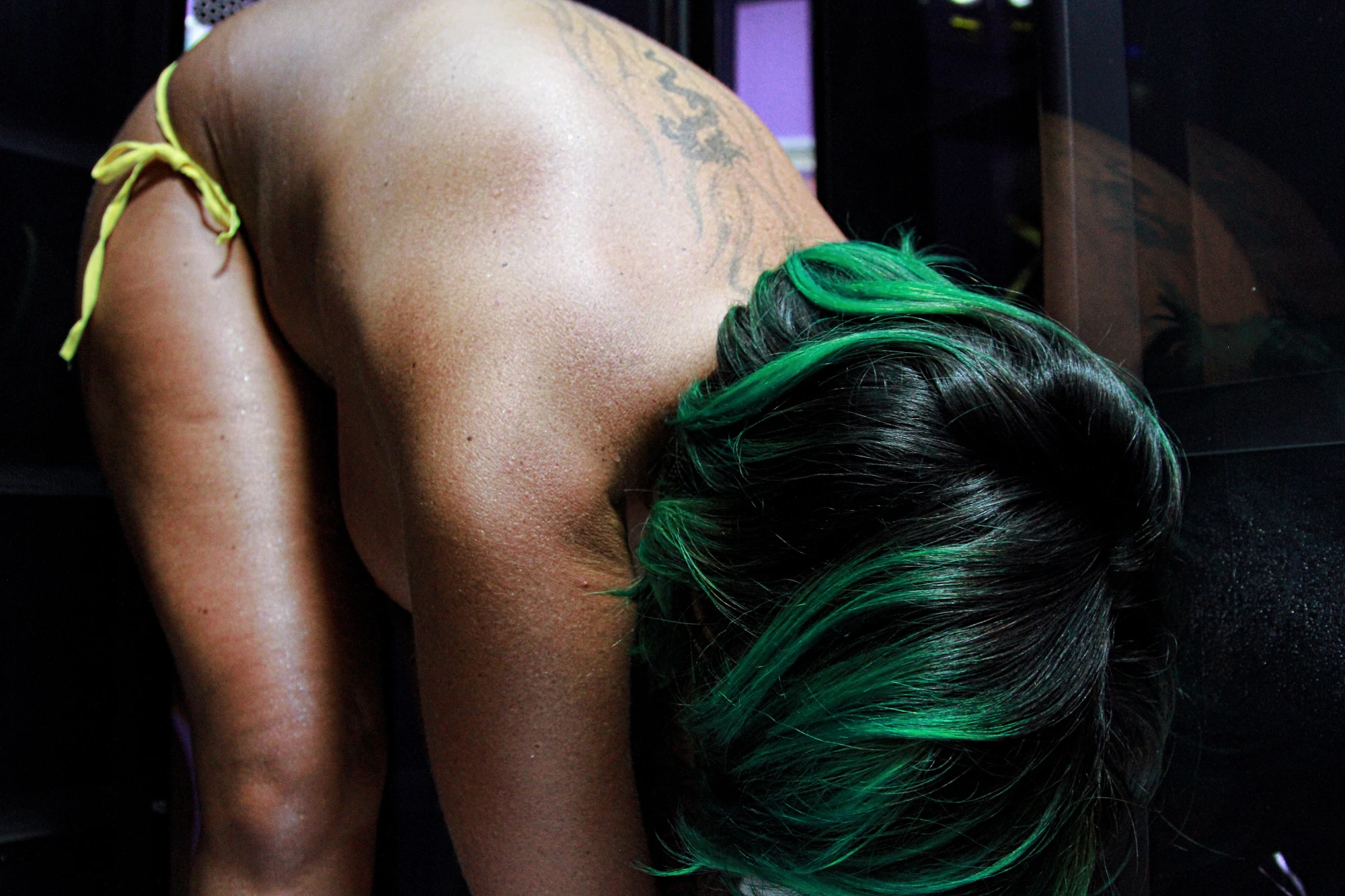 a woman with green hair is bent over.
