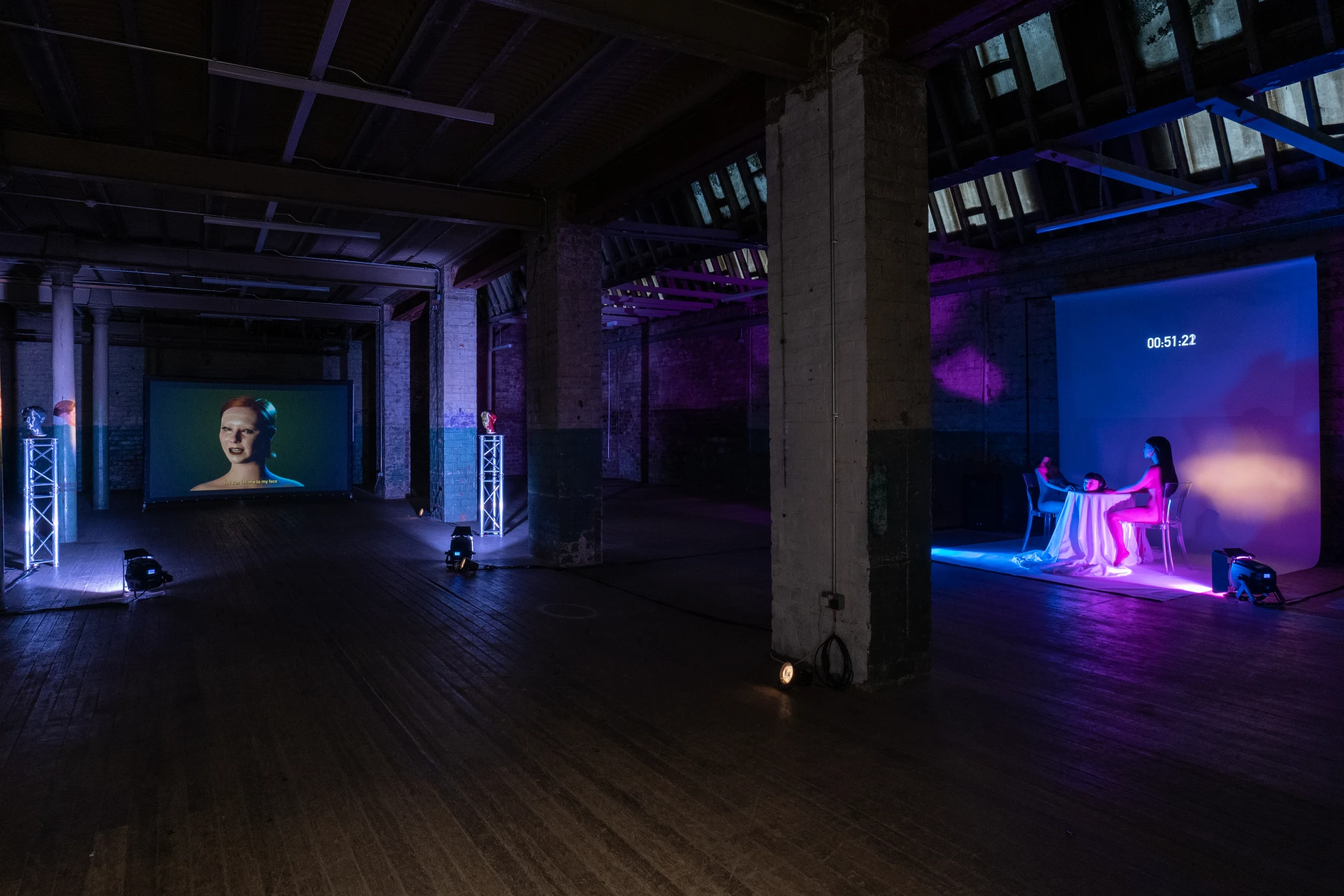 an industrial space stretches out to sjpow two films playing.